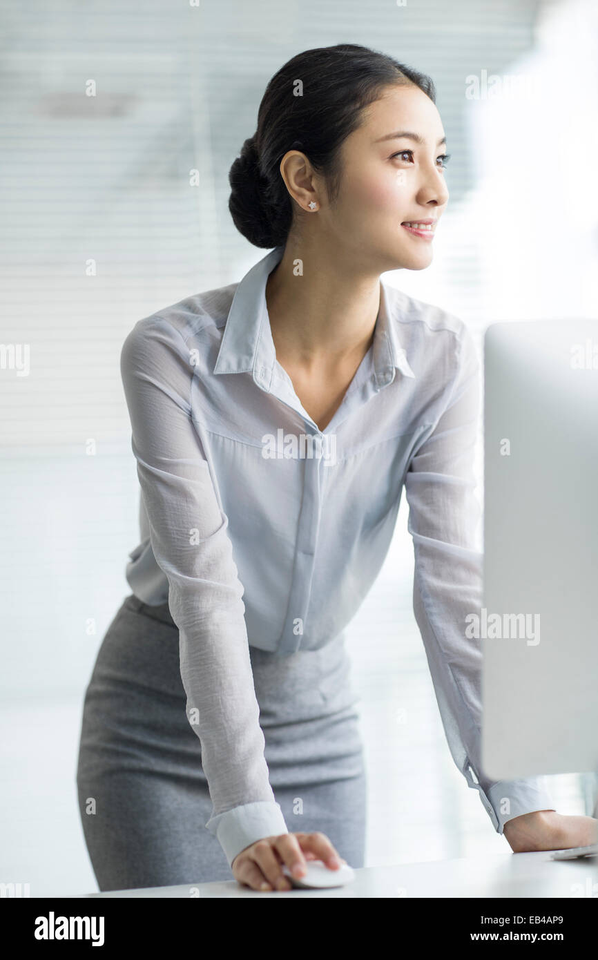Young businesswoman using computer in office Stock Photo - Alamy