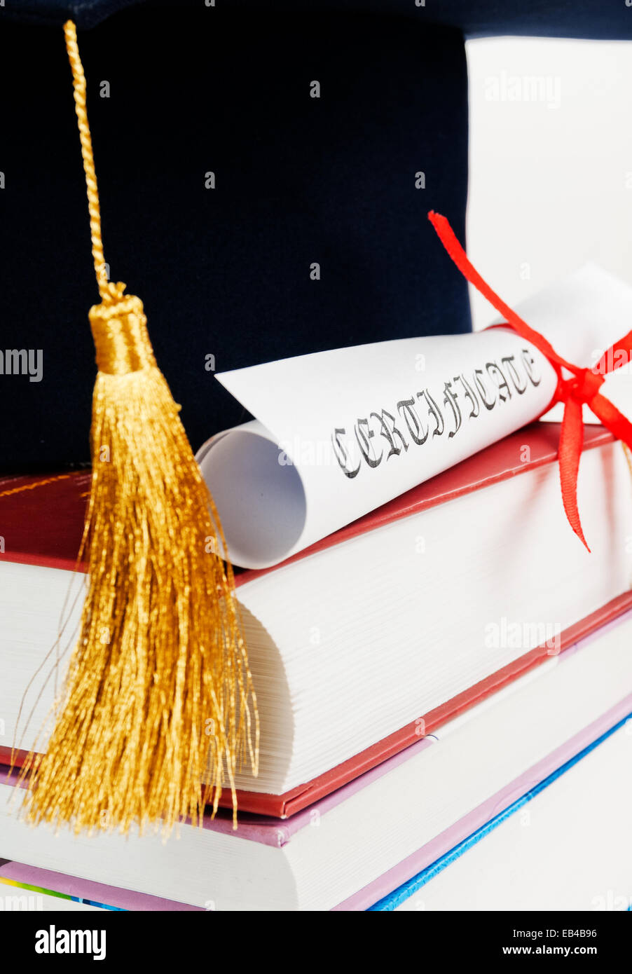 Graduation cap with book and diploma Stock Photo - Alamy