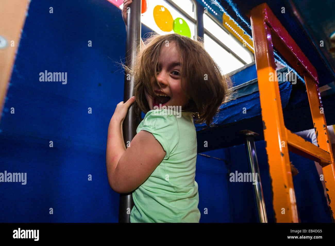 Children playing on a double-decker bus converted into a birthday party venue for gymnastic activities. Stock Photo