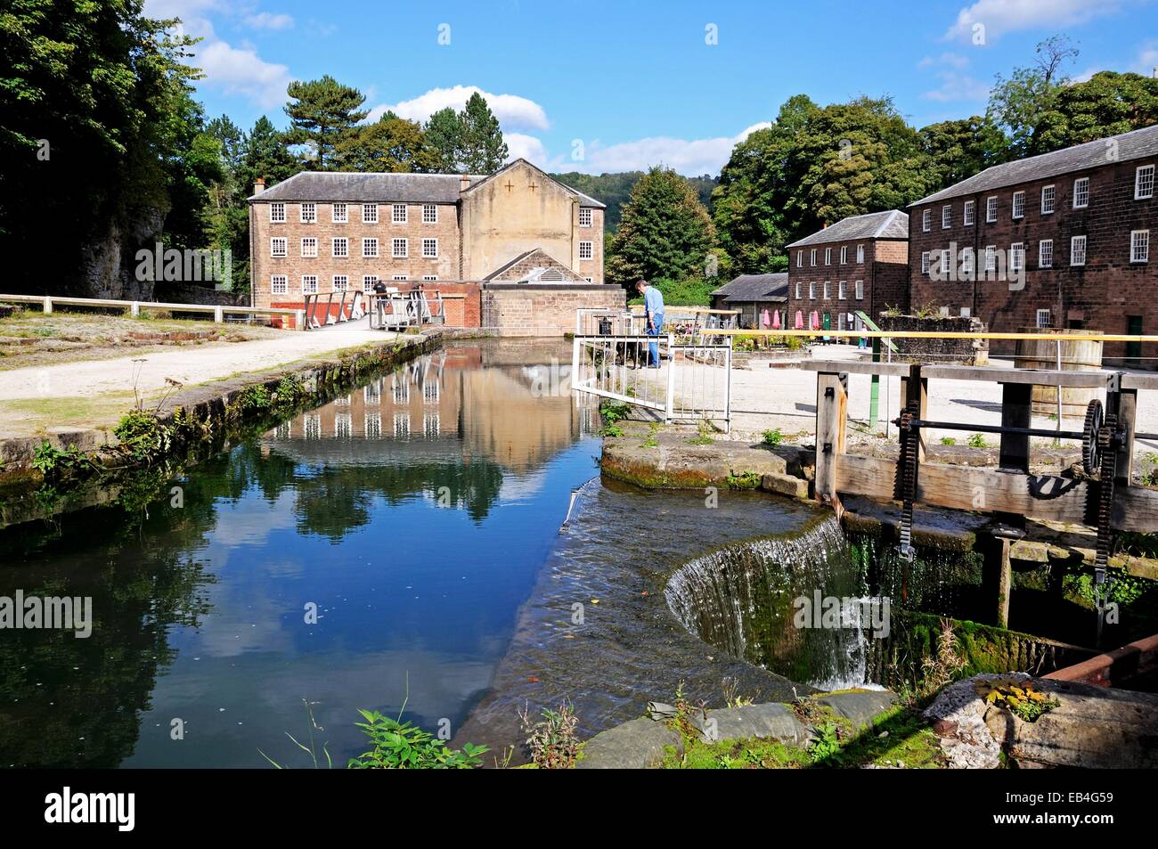 Cromford Mill (water powered cotton spinning mill) with a sluice mechanism in the foreground, Cromford, Derbyshire, England, UK, Stock Photo