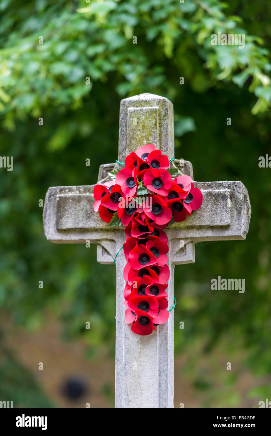 Remembrance Memorial cross of poppies on a cemetery cross in a