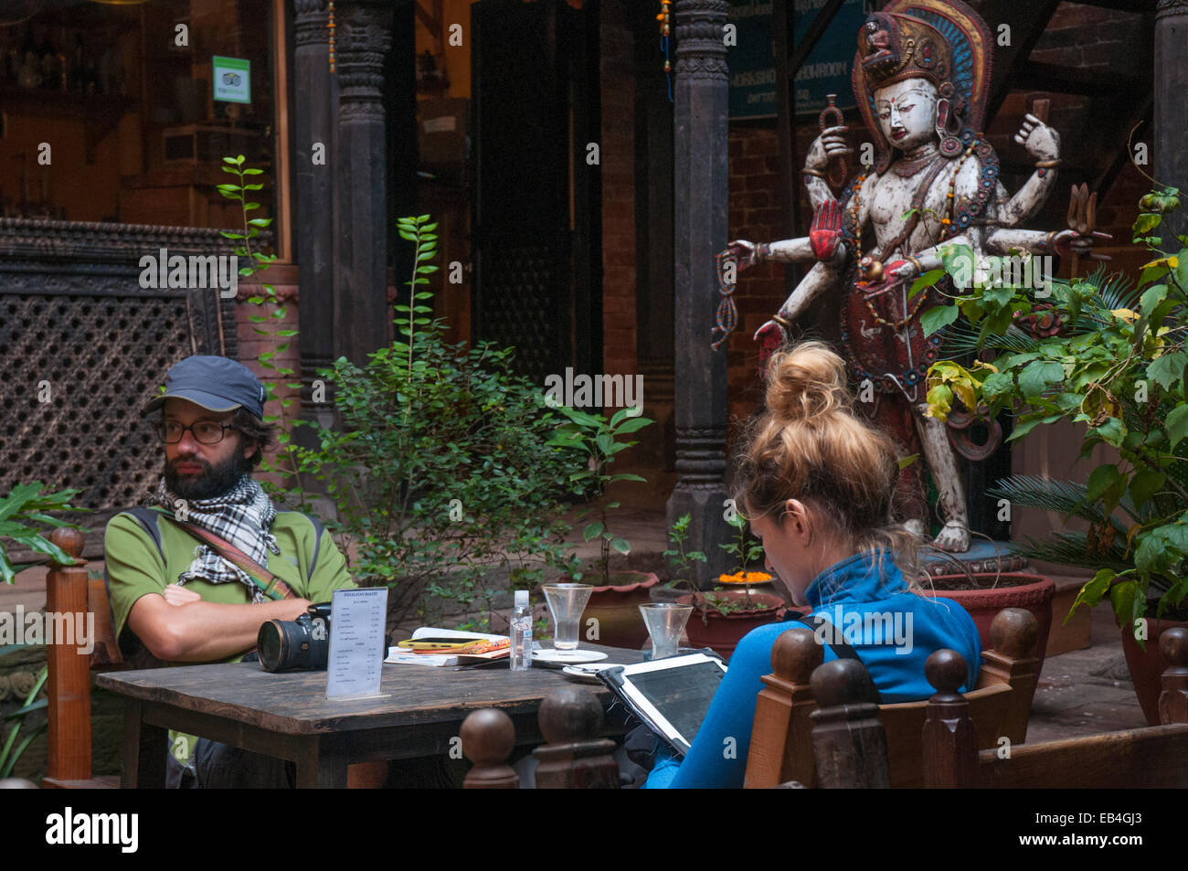 Two tourists in a cafe on Dattatreya Square (Tachapal) in Bhaktapur, Kathmandu Valley Stock Photo