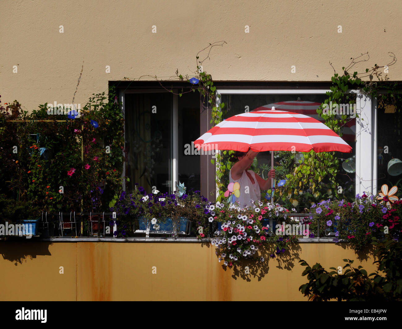 Housewife open her Sun umbrella on the Balcony Stock Photo