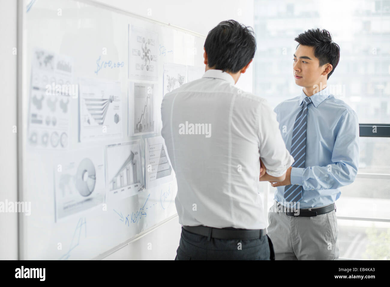 Young businessmen talking in office Stock Photo - Alamy
