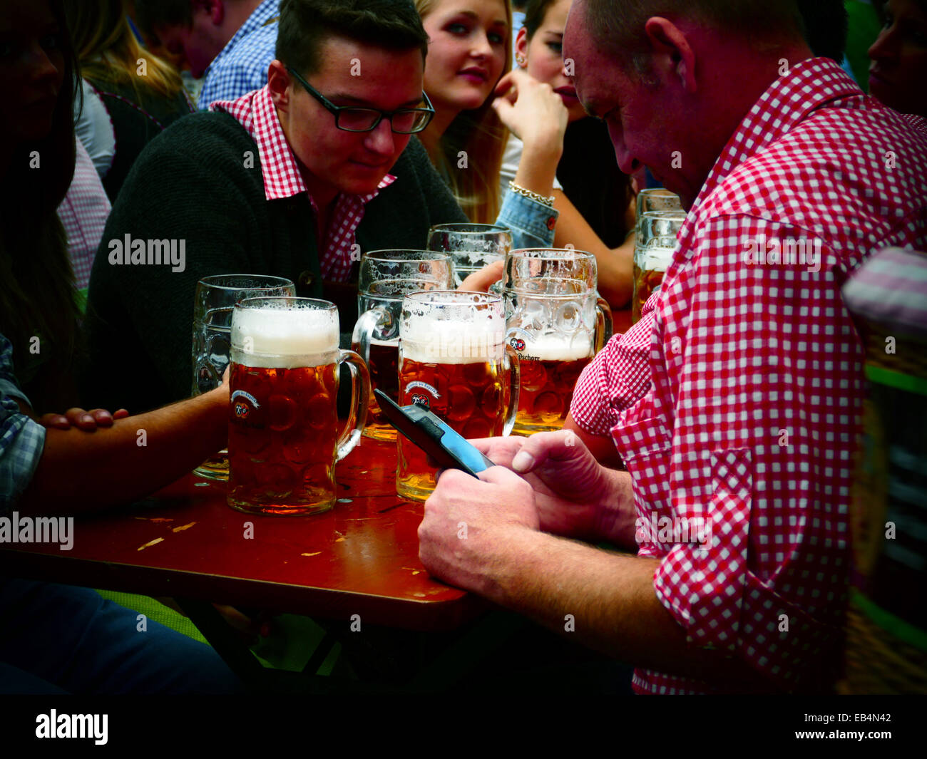 Germany Munich Beer Festival Oktoberfest Octoberfest Fairground 2014 Man texting inside Beer Tent Stock Photo