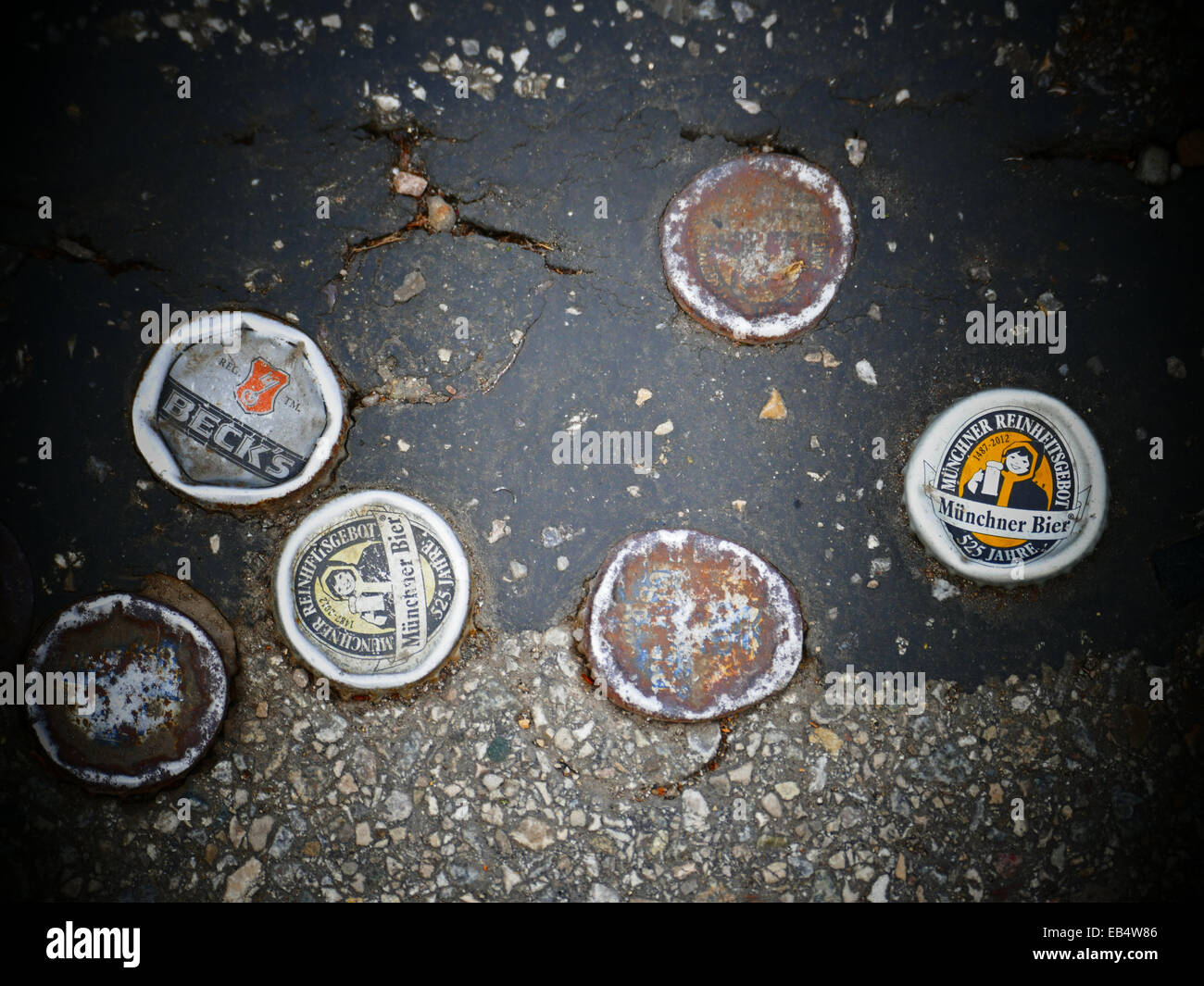 Soft drink metal caps stuck in road Asphalt Stock Photo