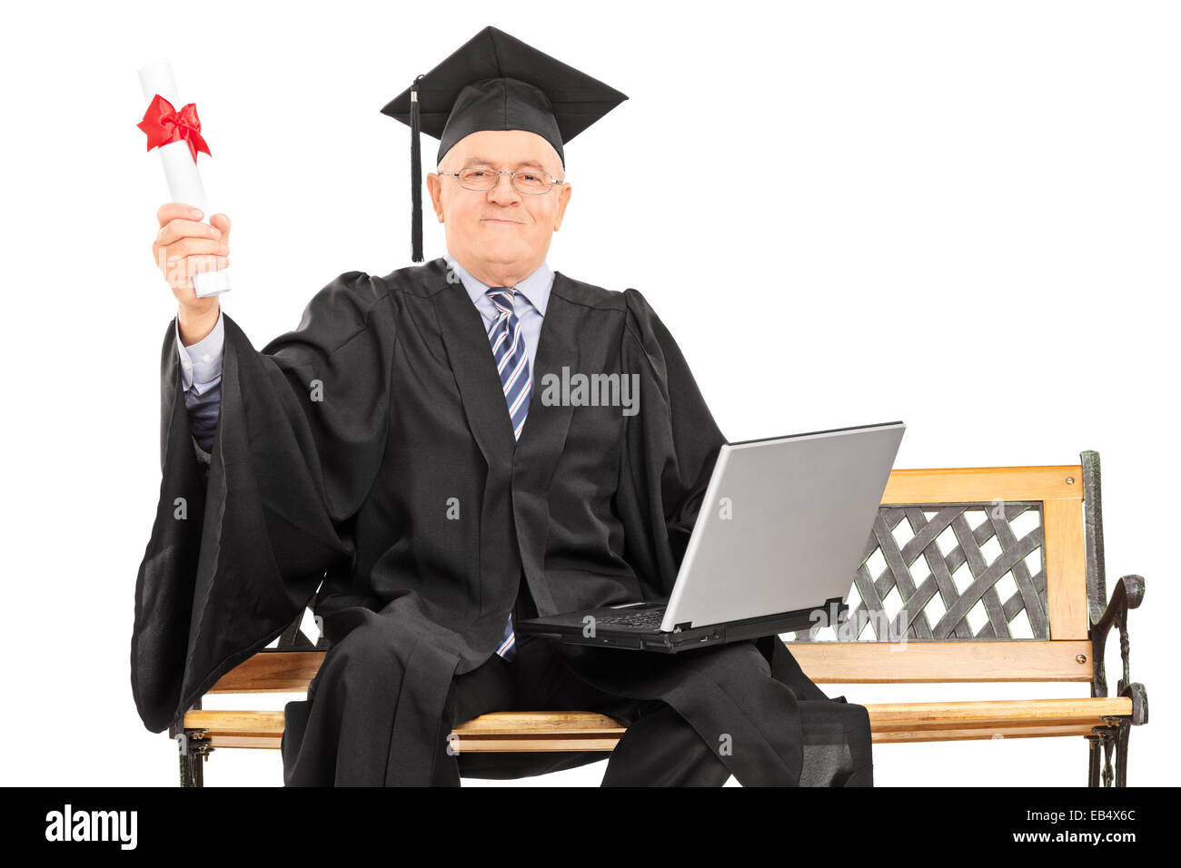 Proud mature graduate holding a diploma seated on a bench isolated on ...