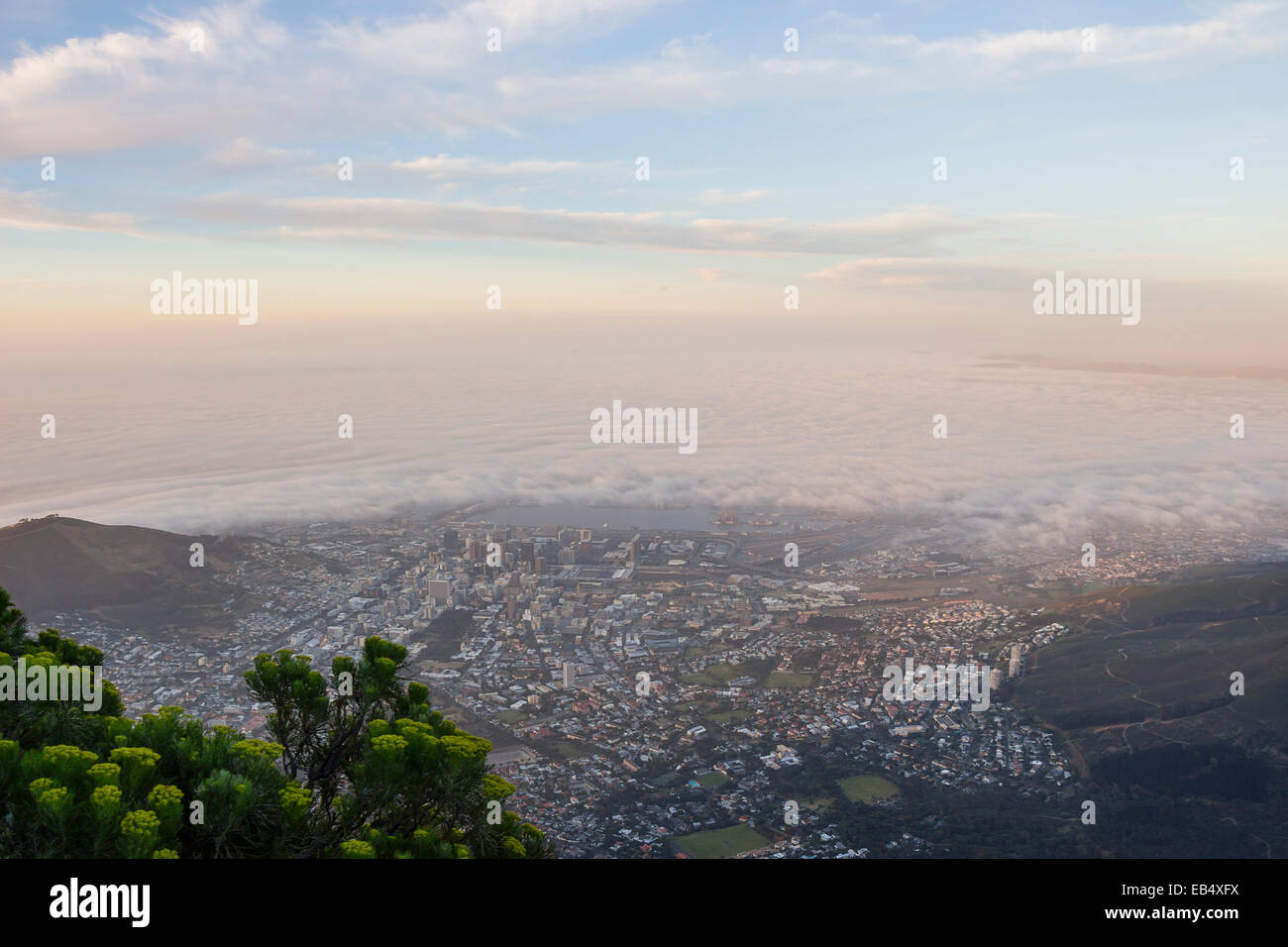Cape Town covered in fog at sunset from Table Mountain Stock Photo