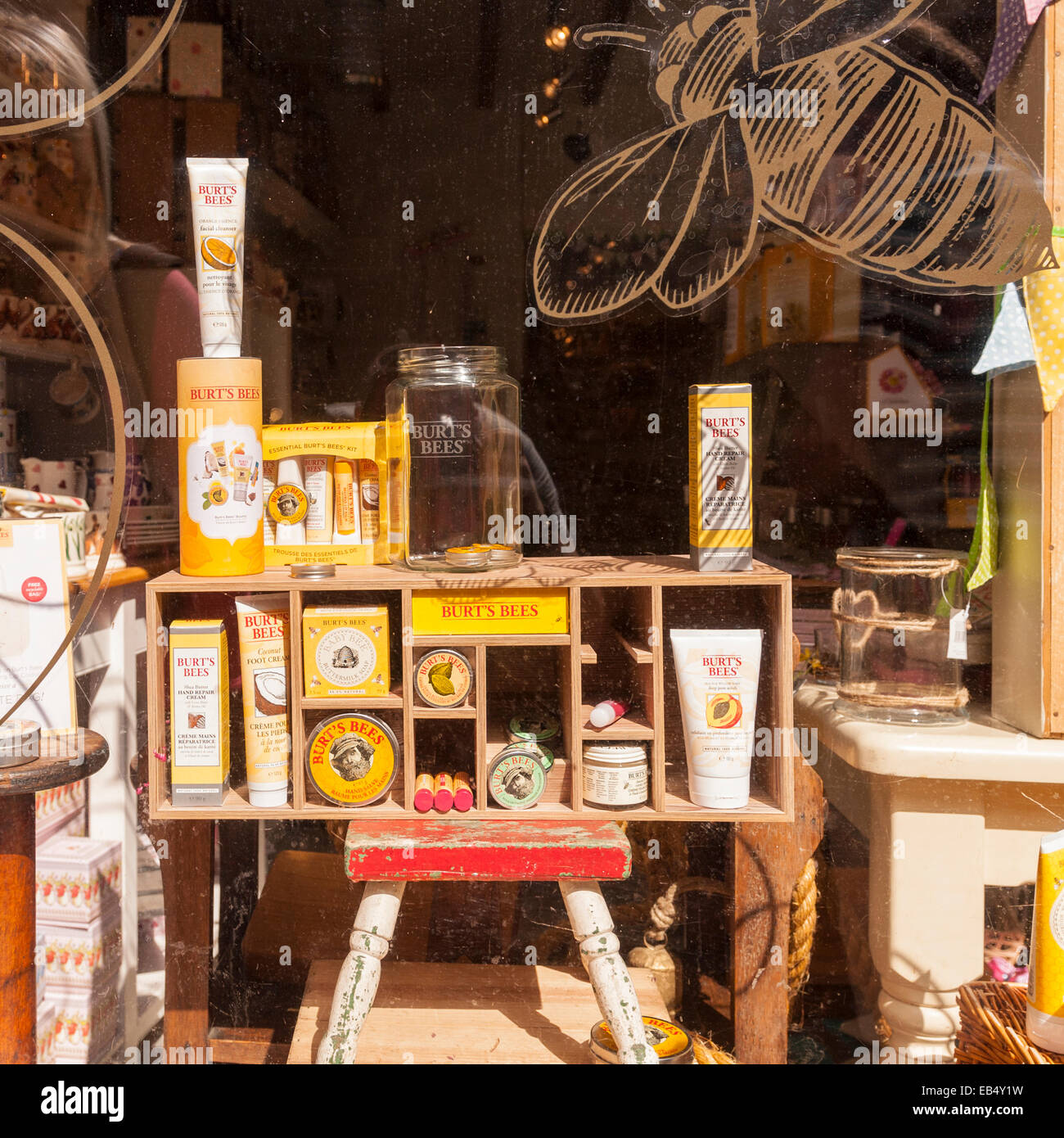A window display showing Burt's Bees products through a dirty window in the Uk Stock Photo