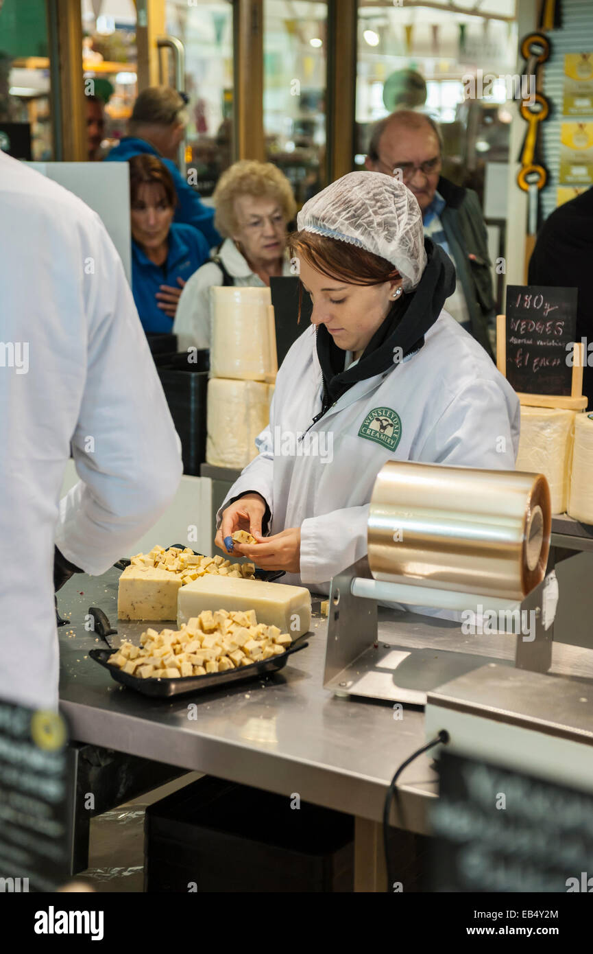 A woman cuts cheese in the Wensleydale creamery at Hawes , Wensleydale ,  in the Yorkshire Dales in Yorkshire , England , uk Stock Photo