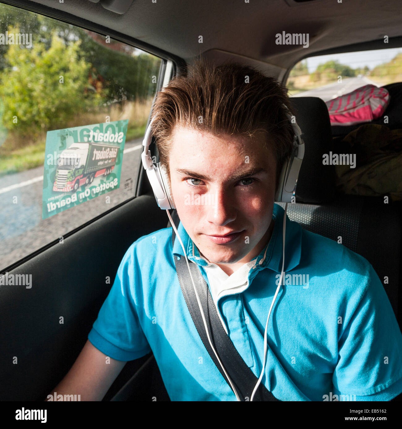 A 14 year old boy listening to music in the car Stock Photo