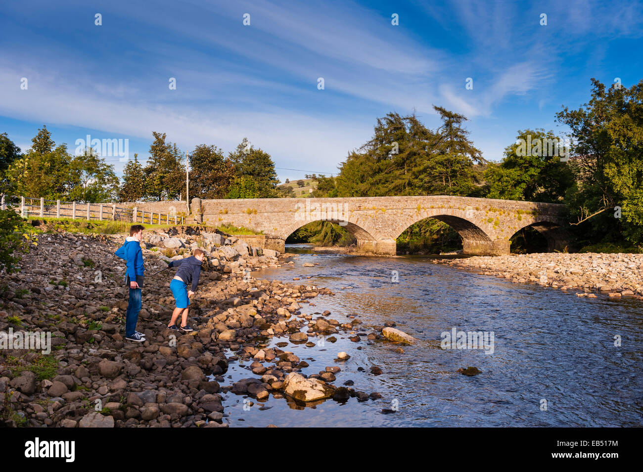 Children playing at the river Swale at Swaledale in the Yorkshire Dales in Yorkshire , England , Britain , Uk Stock Photo