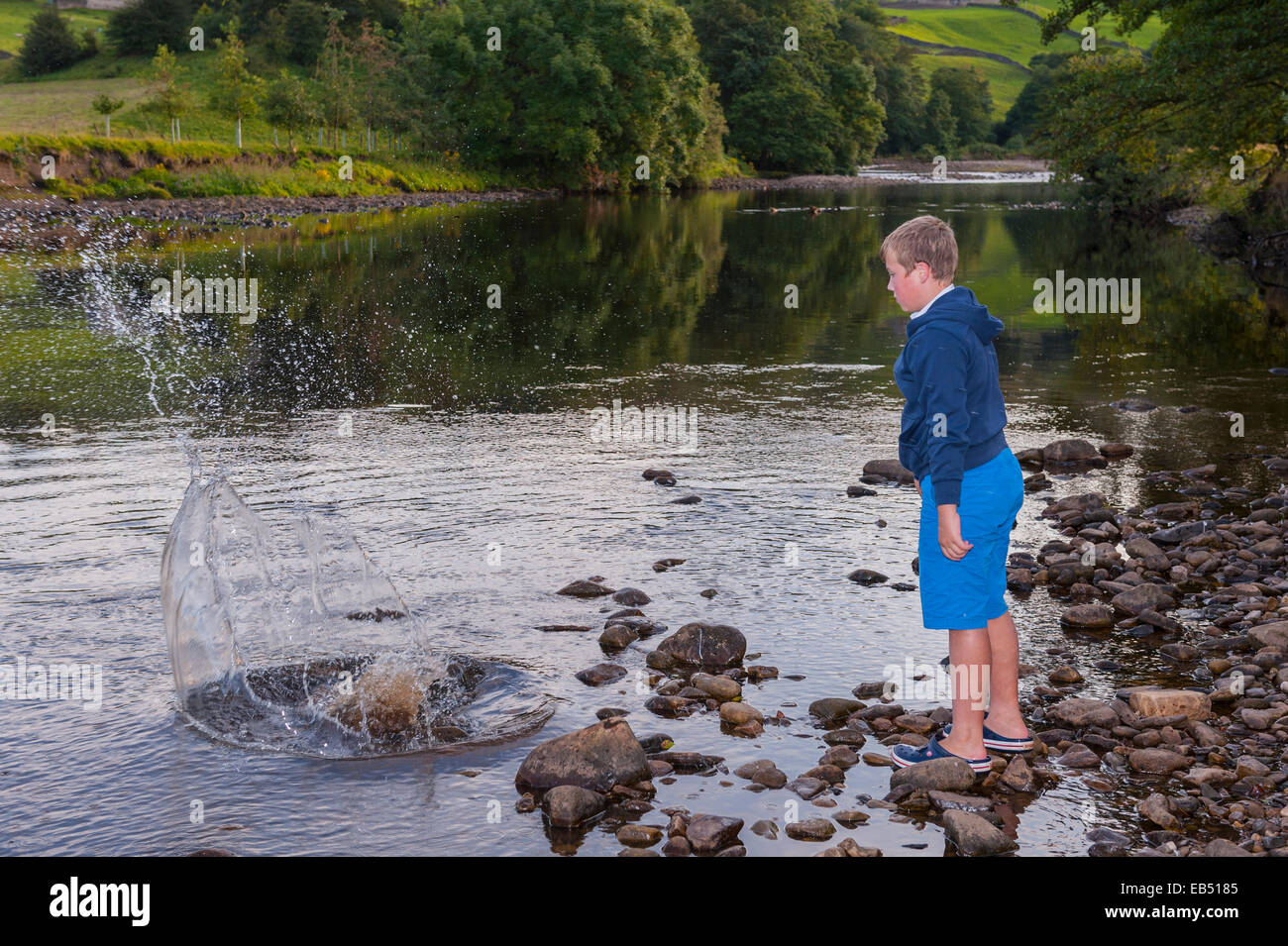 A Child playing at the river Swale at Swaledale in the Yorkshire Dales in Yorkshire , England , Britain , Uk Stock Photo