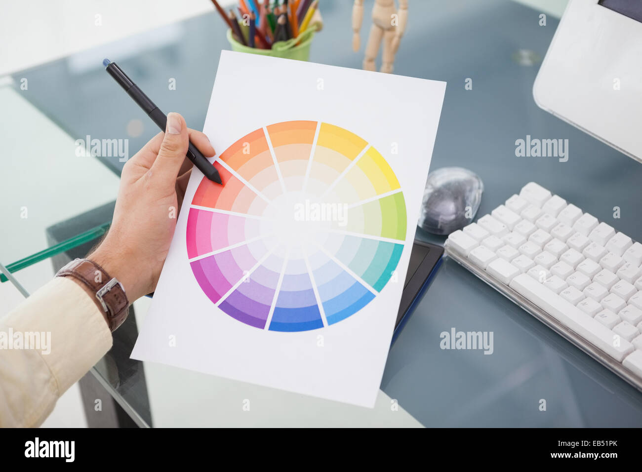 Designer working at desk using a colour wheel Stock Photo