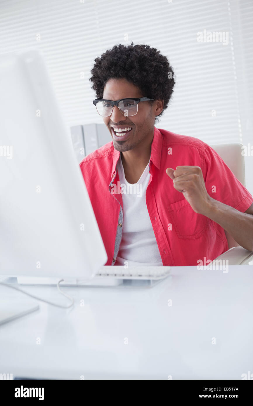 Happy businessman cheering at his desk Stock Photo - Alamy