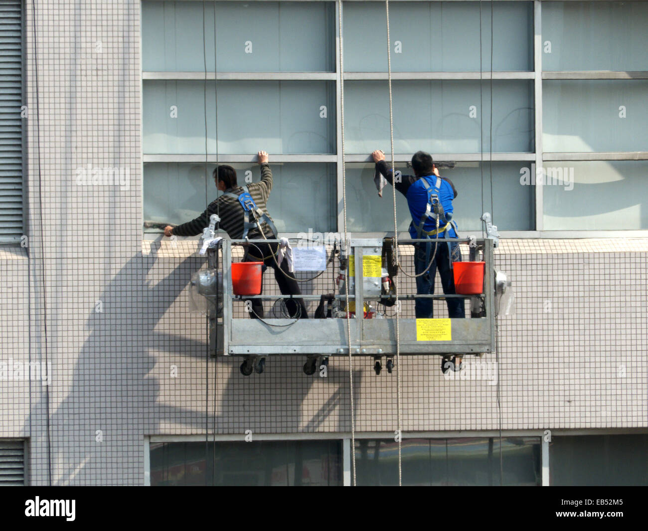 China Hong Kong Cleaning worker cleaning building's glass facade Stock