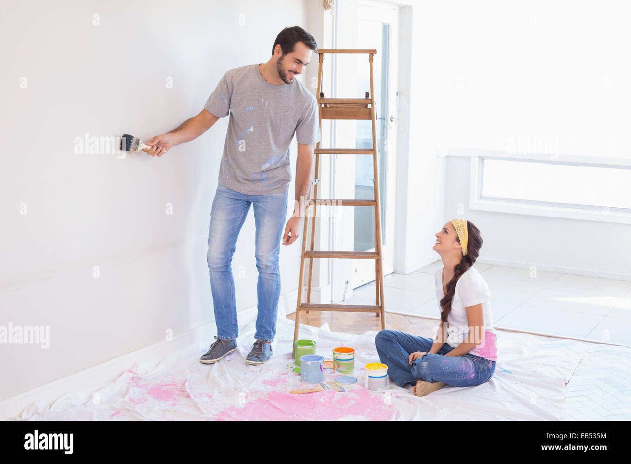 Cute couple redecorating living room Stock Photo - Alamy