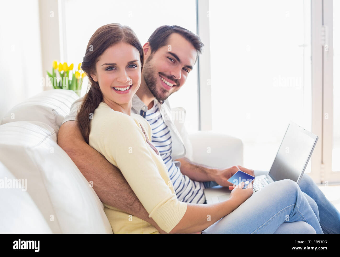 Cute couple relaxing on couch with laptop Stock Photo - Alamy