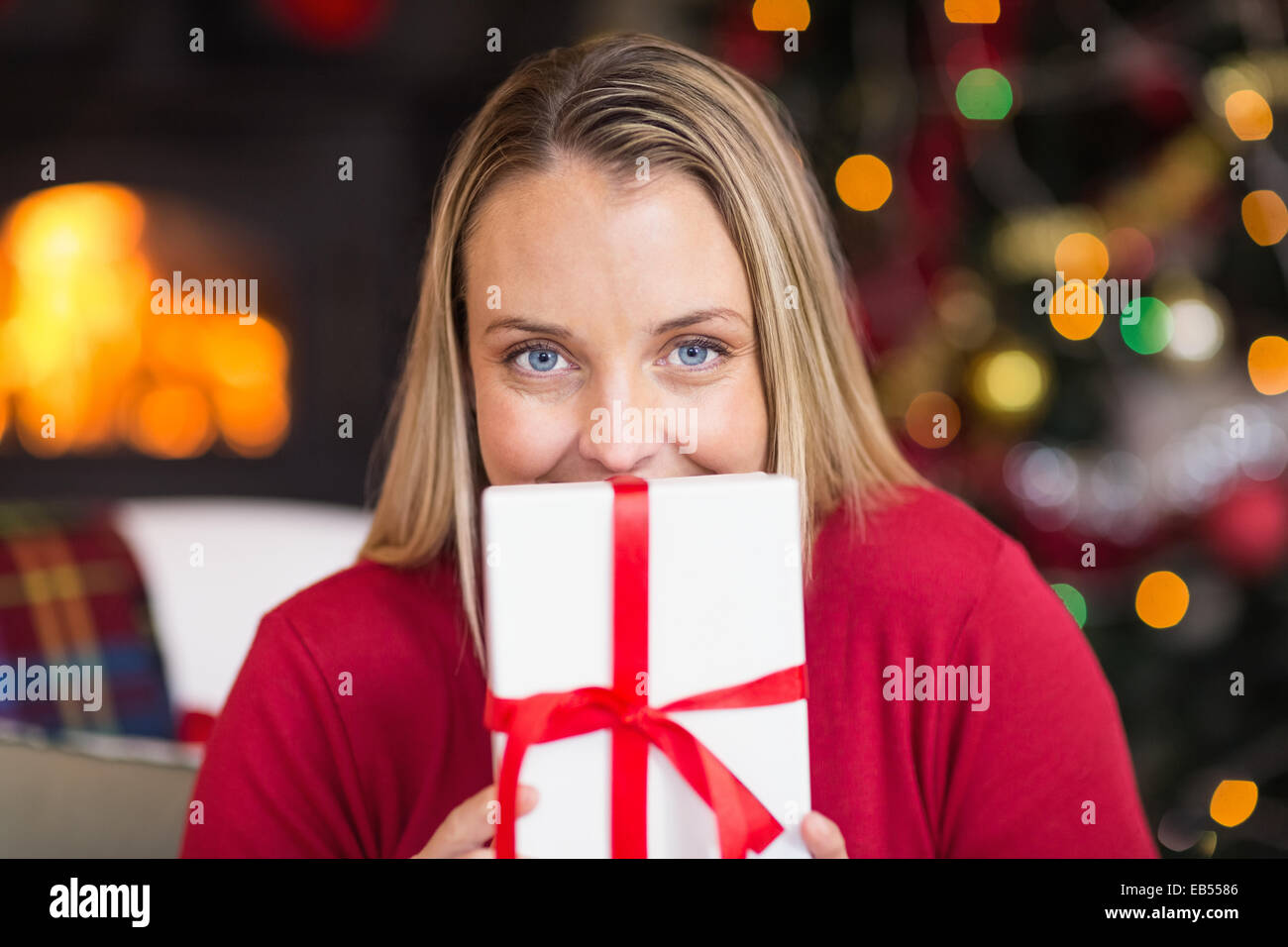 Pretty blonde woman holding christmas gift Stock Photo - Alamy