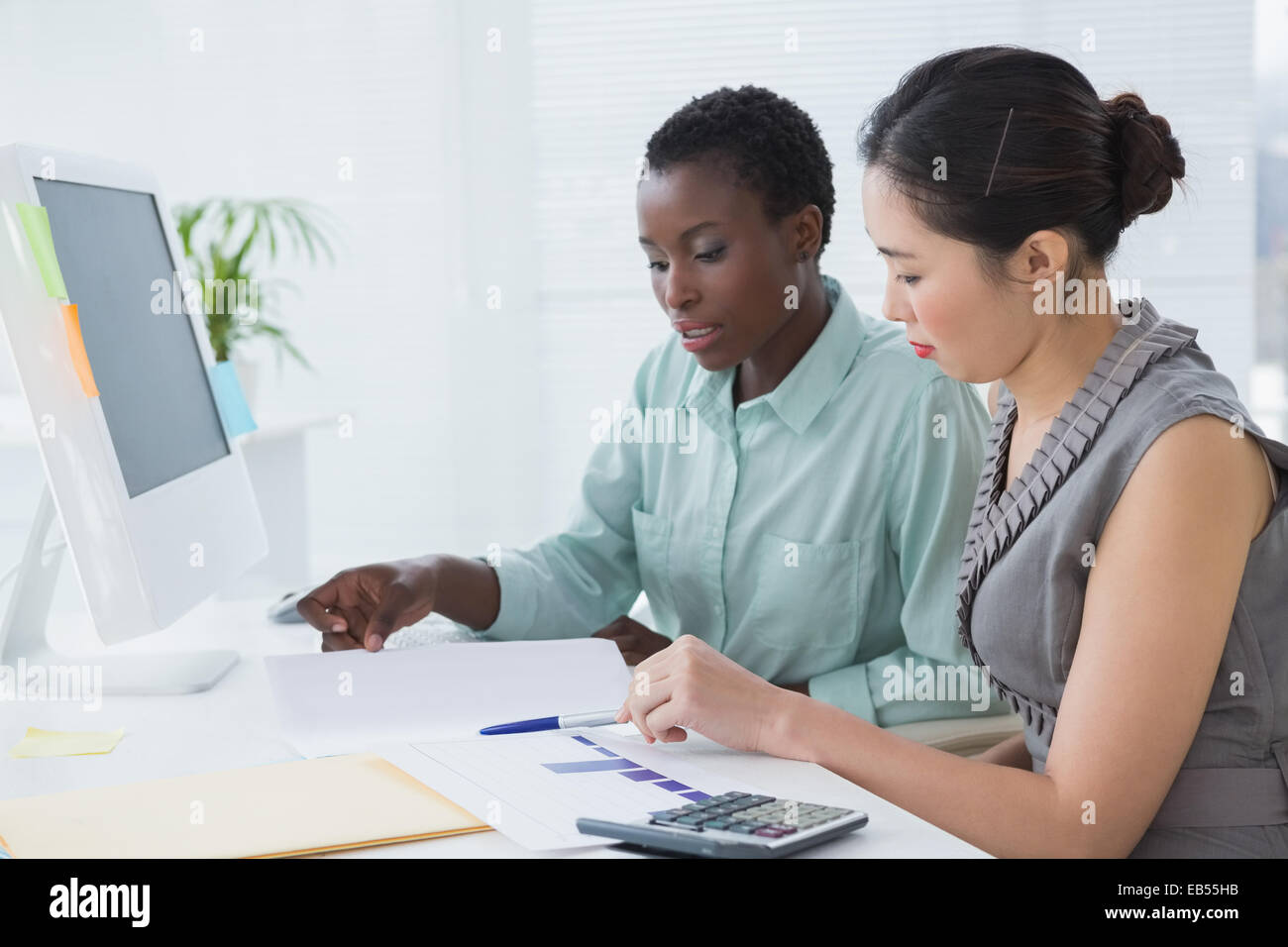 Businesswomen working together at desk Stock Photo - Alamy
