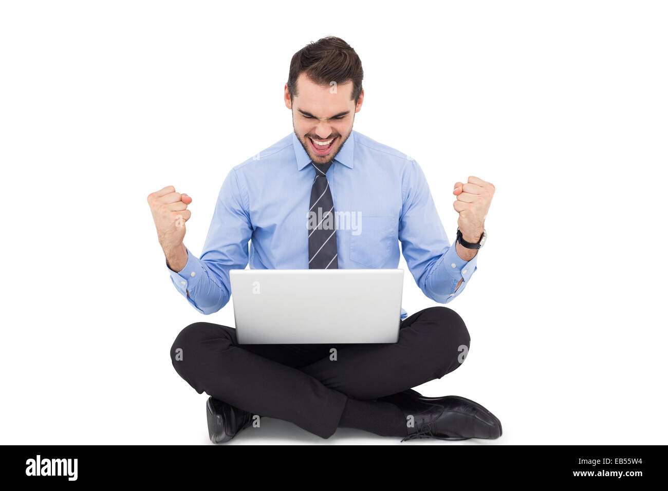 Businessman sitting with his laptop cheering Stock Photo - Alamy