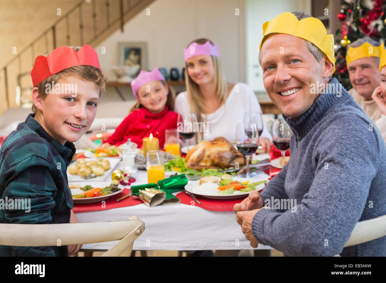 Smiling extended family in party hat at dinner table Stock Photo Alamy