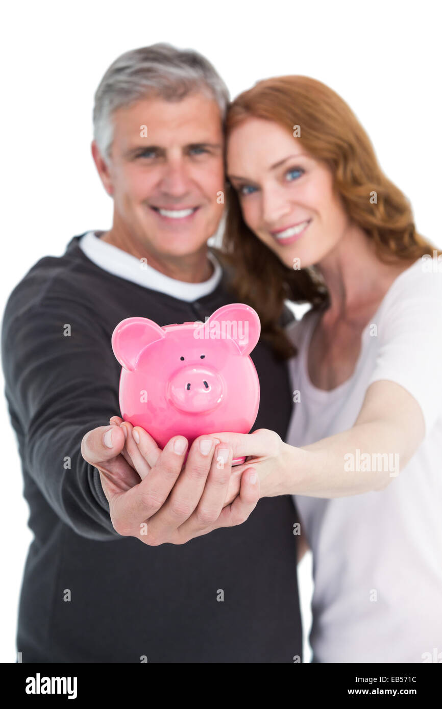 Casual couple showing their piggy bank Stock Photo - Alamy
