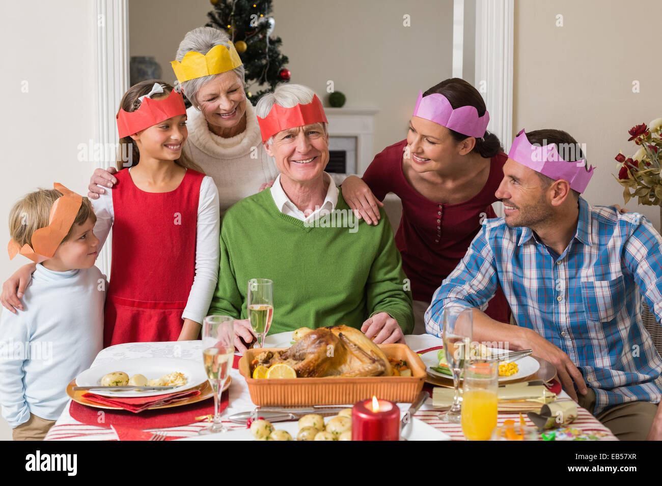 Happy extended family in party hat at dinner table Stock Photo Alamy