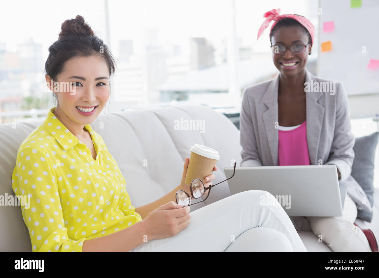 Young creative women chatting on the couch Stock Photo - Alamy