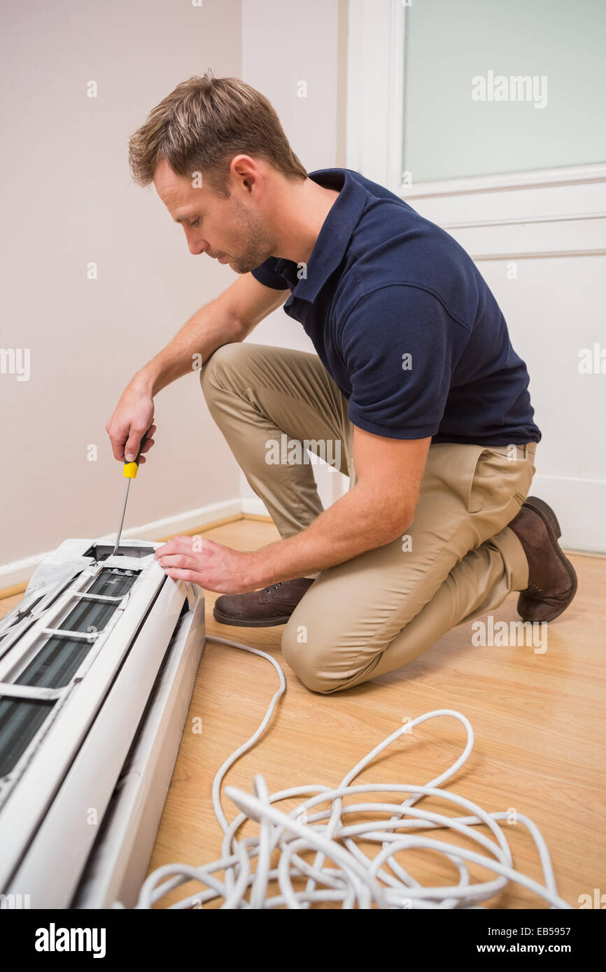 Focused handyman fixing air conditioning Stock Photo Alamy