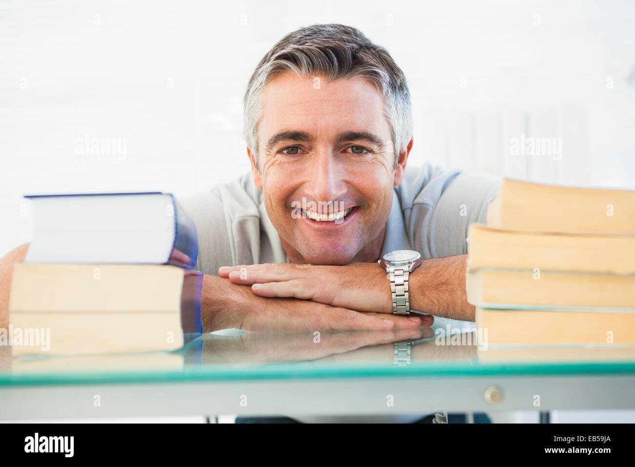 Happy man posing between books Stock Photo - Alamy