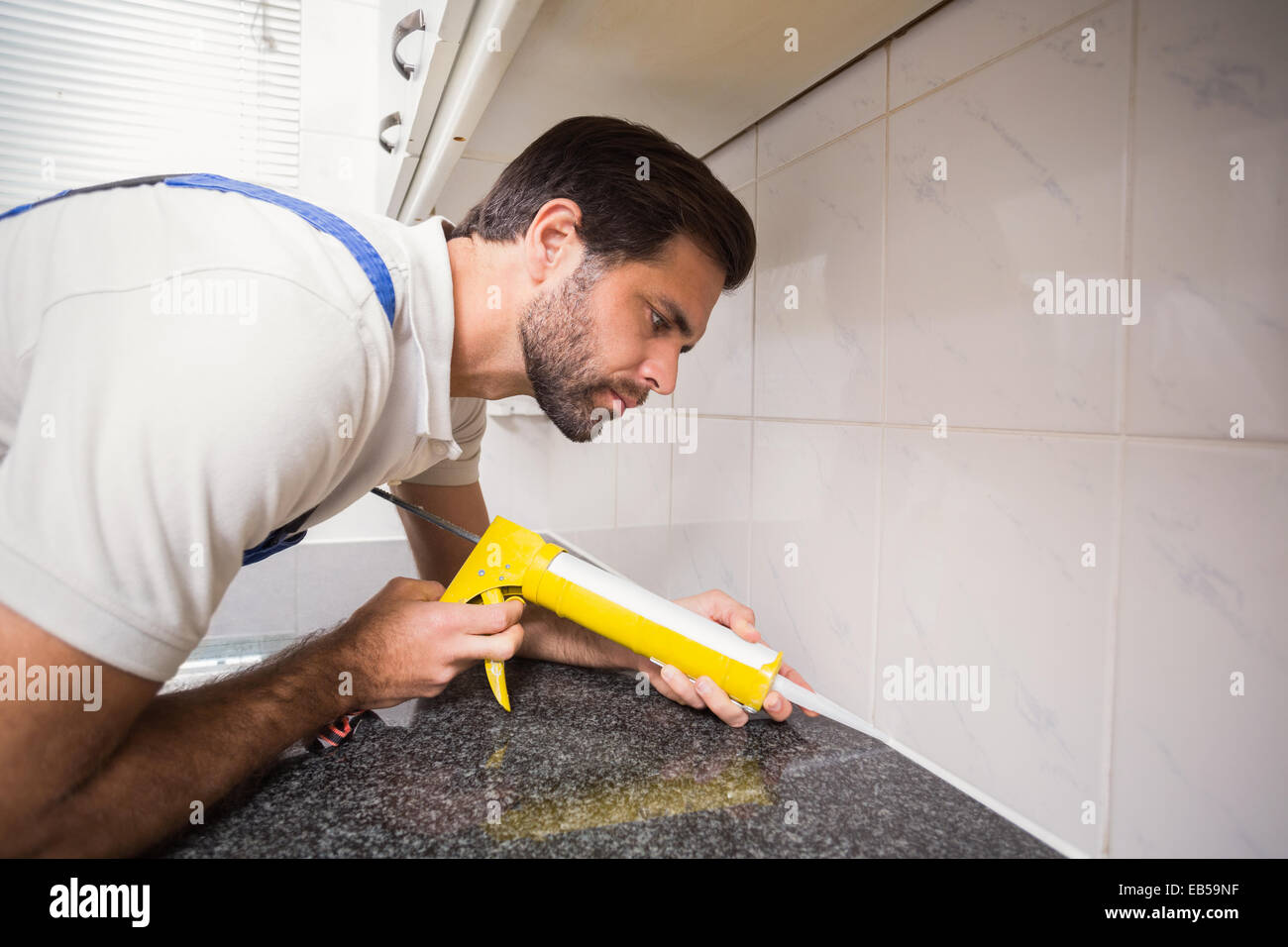 Plumber putting filling in between tiles Stock Photo Alamy