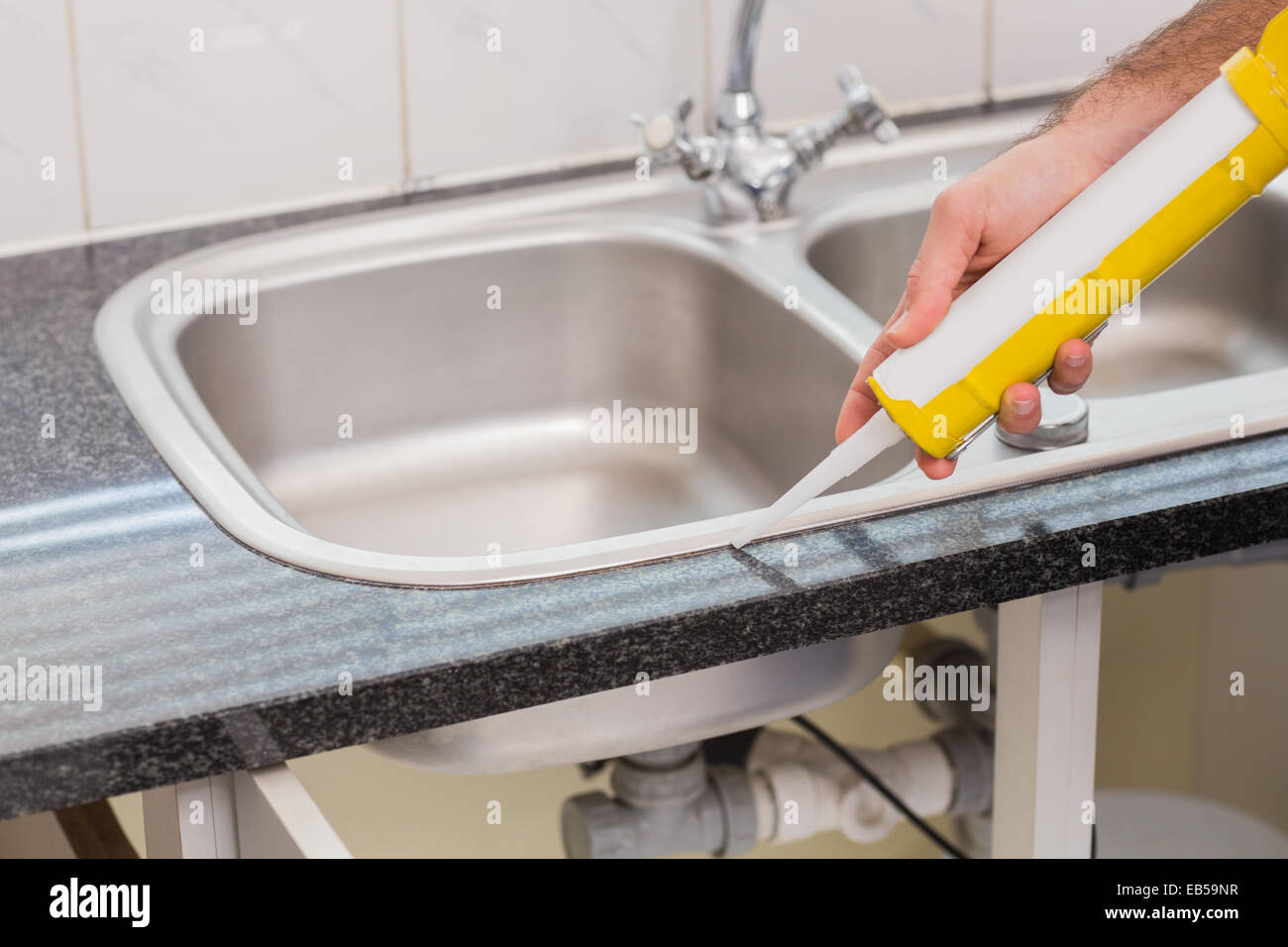 Plumber putting filling in between tiles Stock Photo Alamy