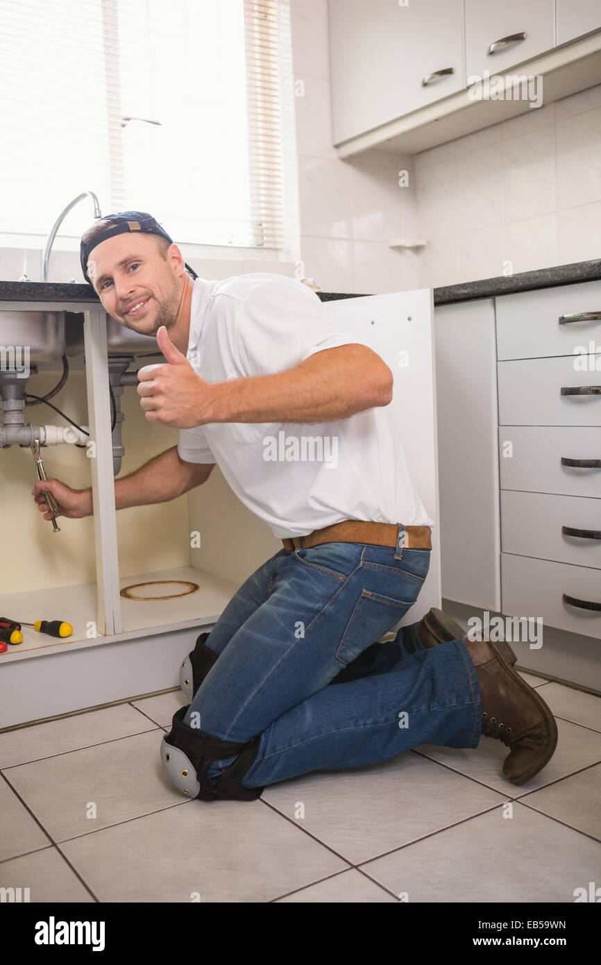 Plumber fixing under the sink Stock Photo - Alamy