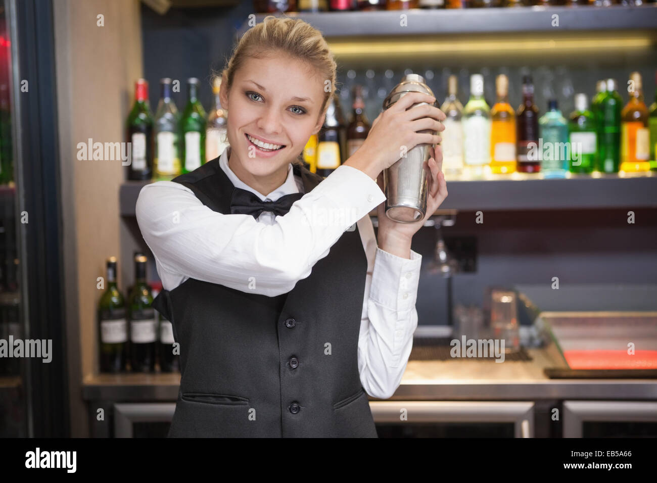 Pretty blonde waitress shaking cocktail Stock Photo Alamy