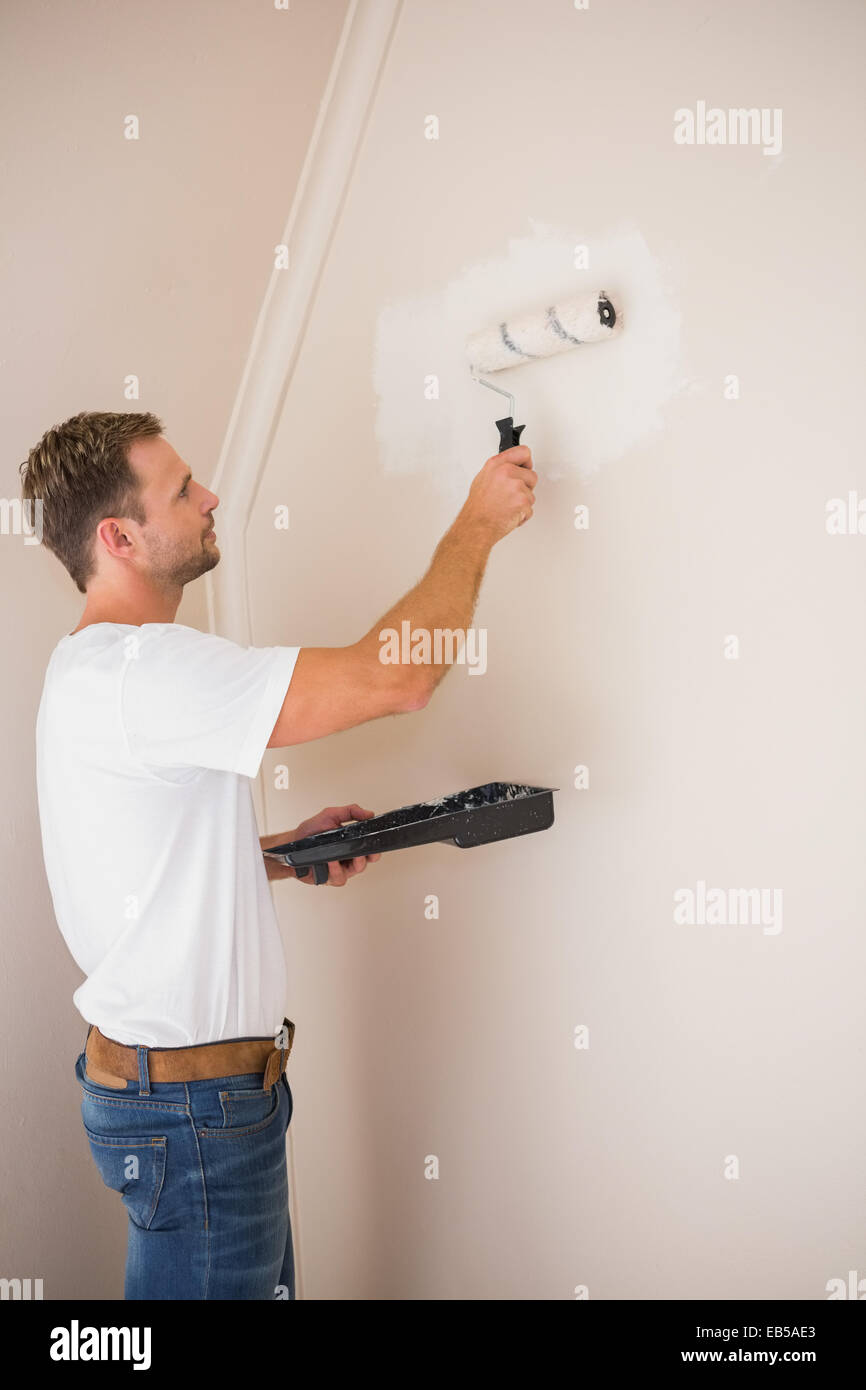 Painter painting the walls white Stock Photo Alamy