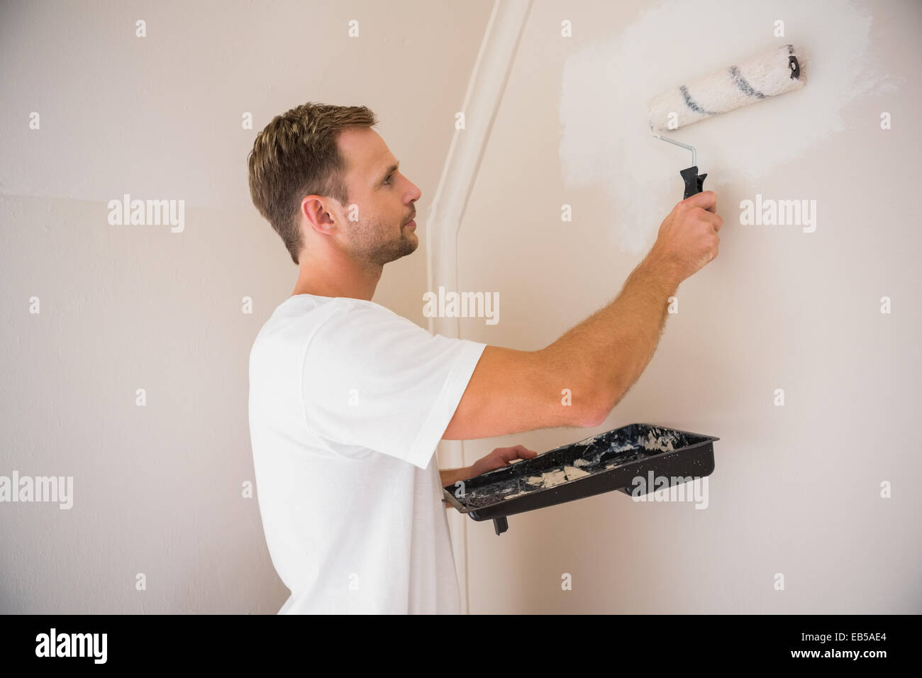 Painter painting the walls white Stock Photo Alamy