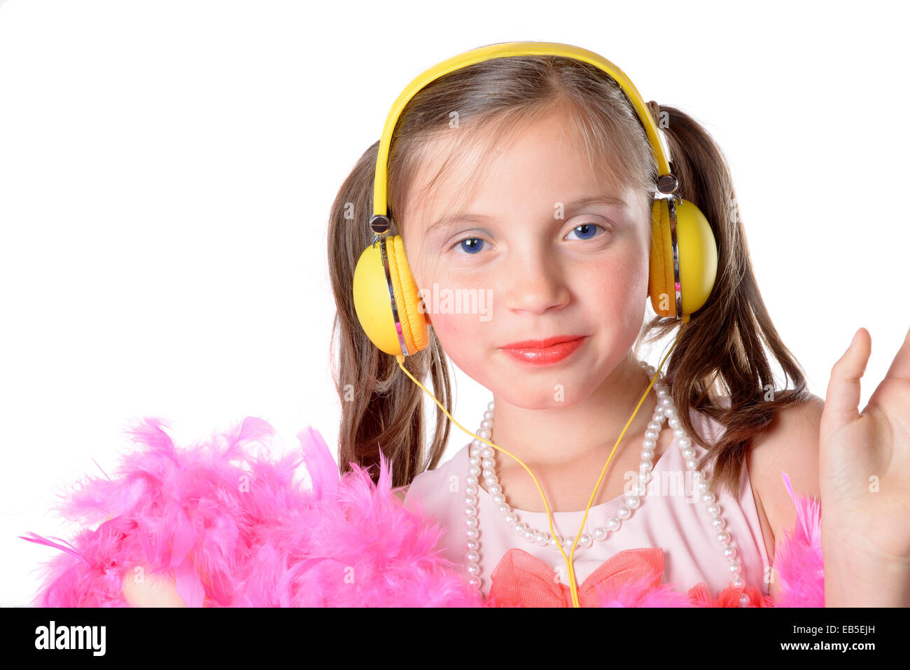 portrait of a little girl with a yellow headphones on white background ...