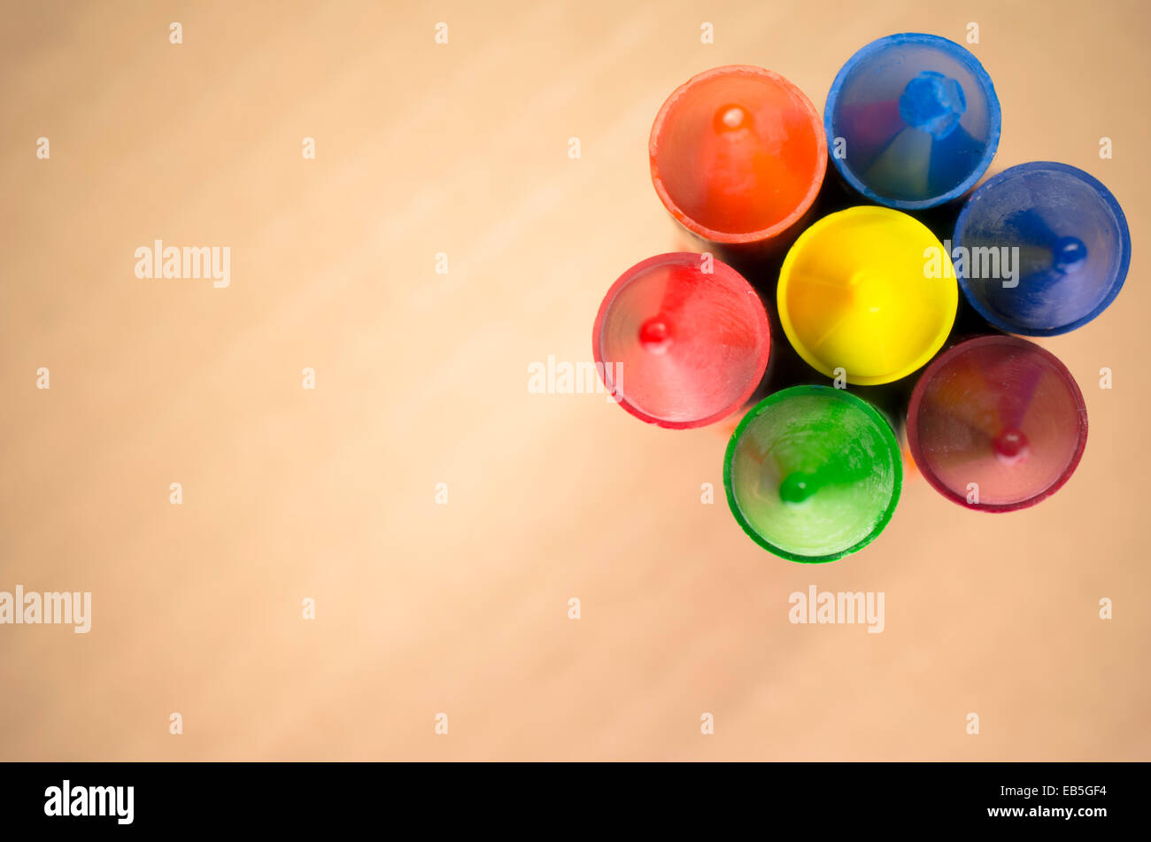 colored wax crayons close up on a blurred light paperboard background ...
