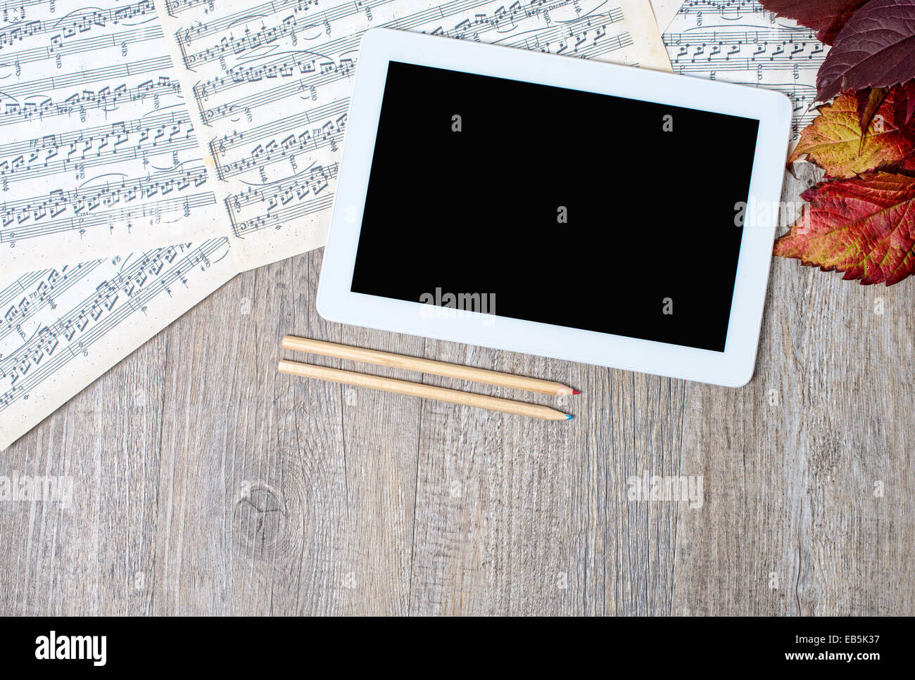 musical scores with a digital tablet placed on an ancient table Stock Photo