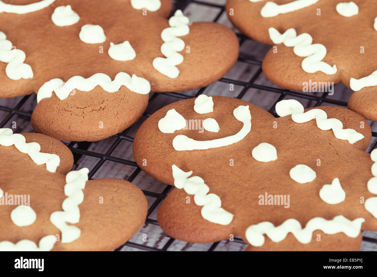 Freshly baked gingerbread man cookies on cooling rack, closeup Stock Photo