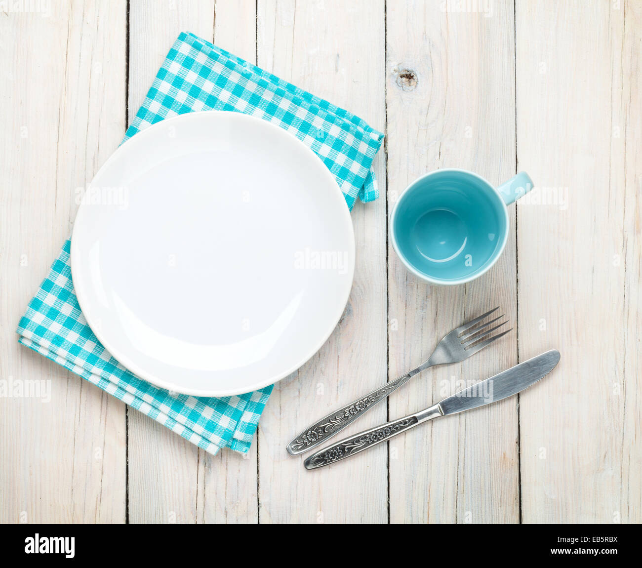 Empty plate, cup and silverware over white wooden table background. View from above Stock Photo