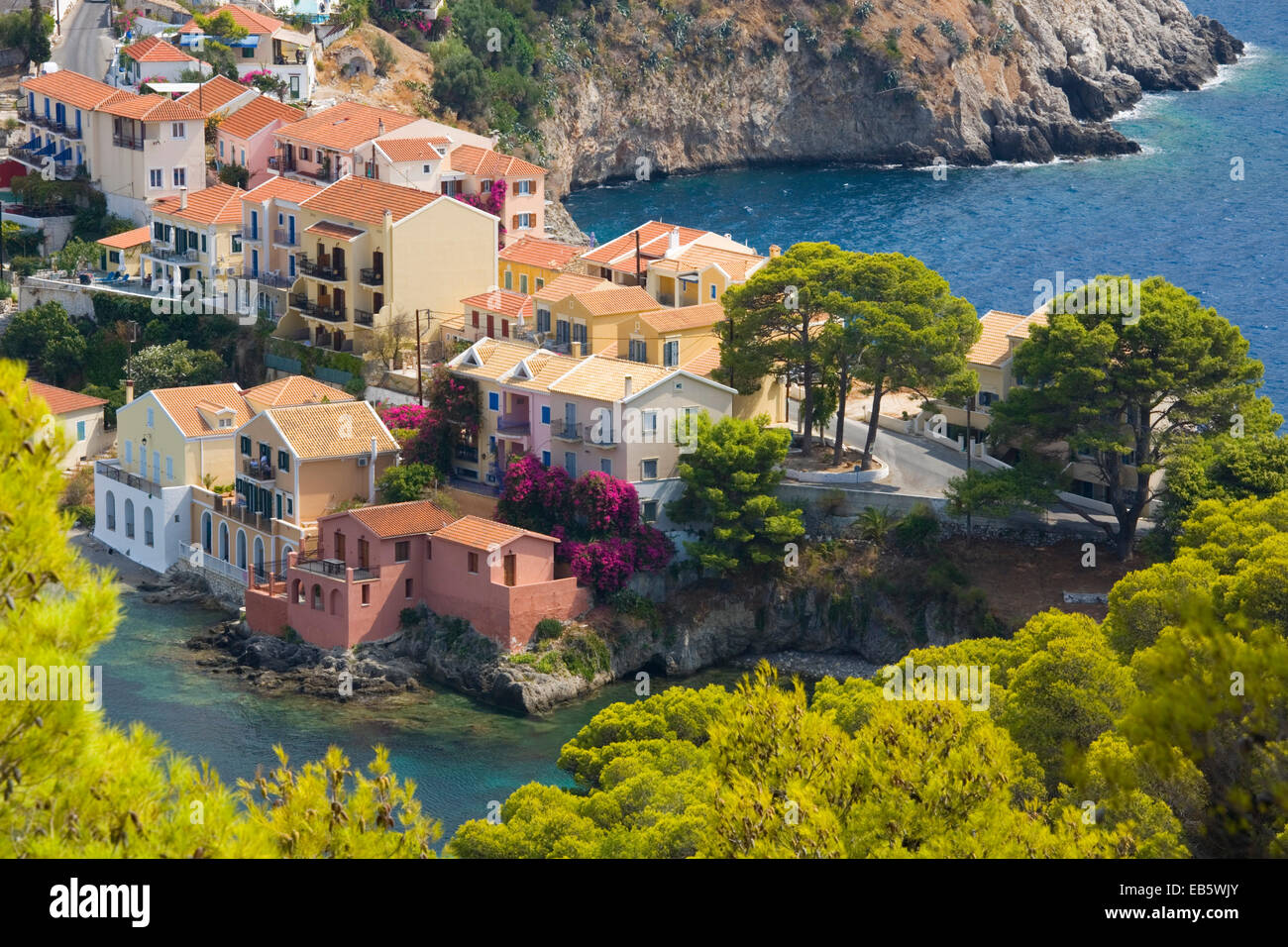 Asos, Kefalonia, Ionian Islands, Greece. View from hillside to pastel-coloured houses on isthmus above the harbour. Stock Photo