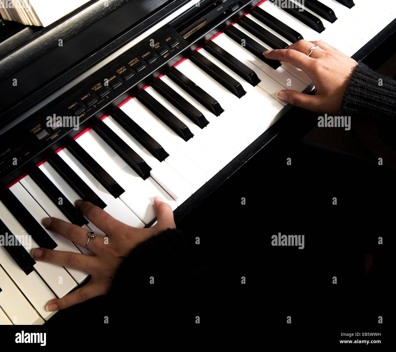 Young woman playing piano / keyboard at a church recital Stock Photo