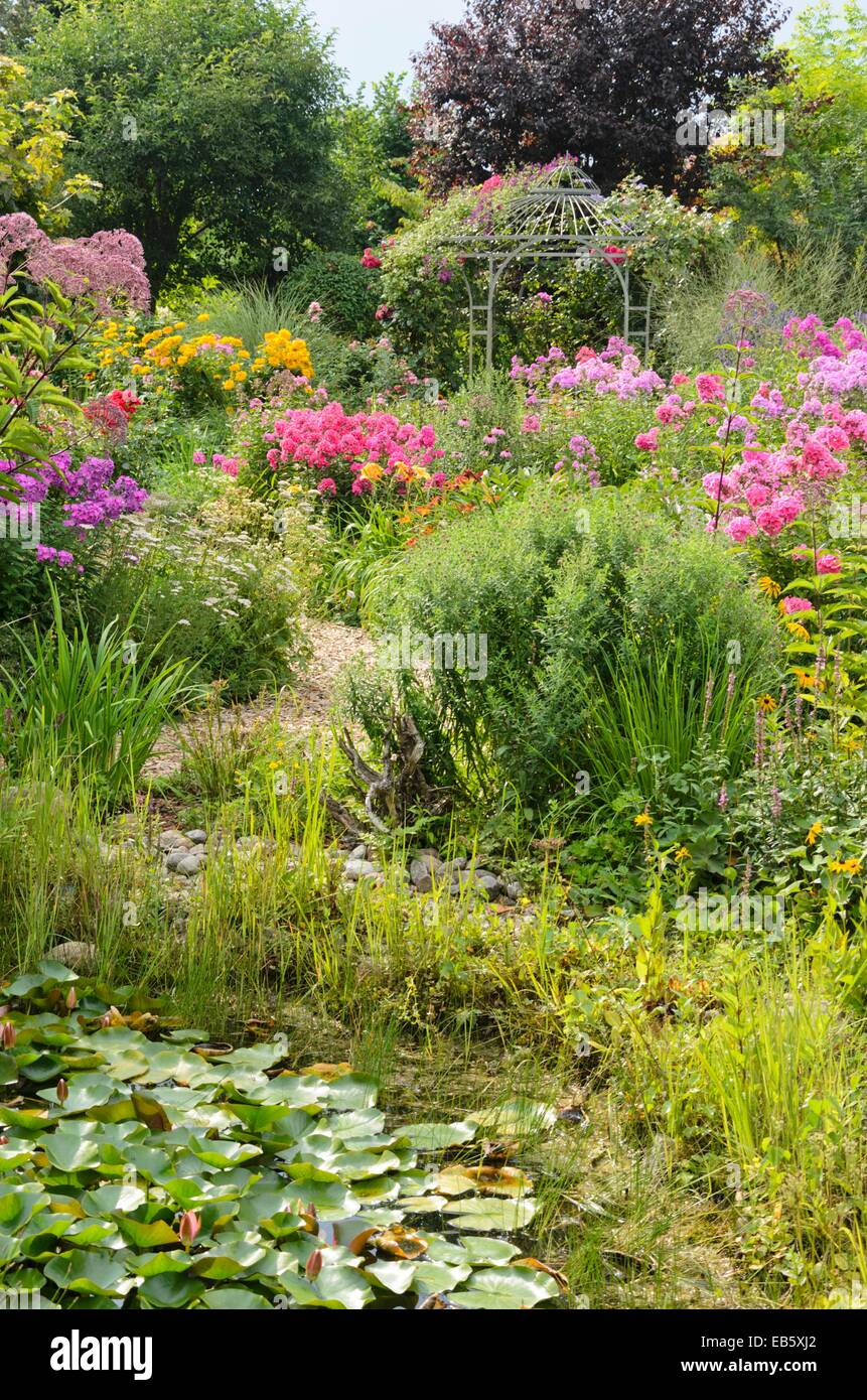 Garden phlox (Phlox paniculata) and rose (Rosa) with garden pavilion. Design: Marianne and Detlef Lüdke Stock Photo