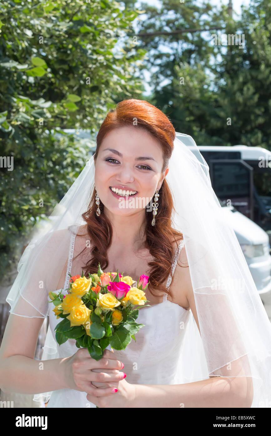 smiling happily at bride with bouquet of flowers Stock Photo
