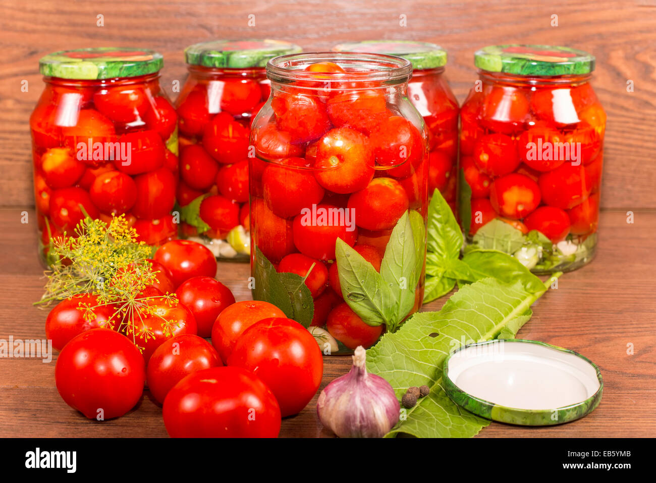 canning tomatoes in glass jars with spices Stock Photo