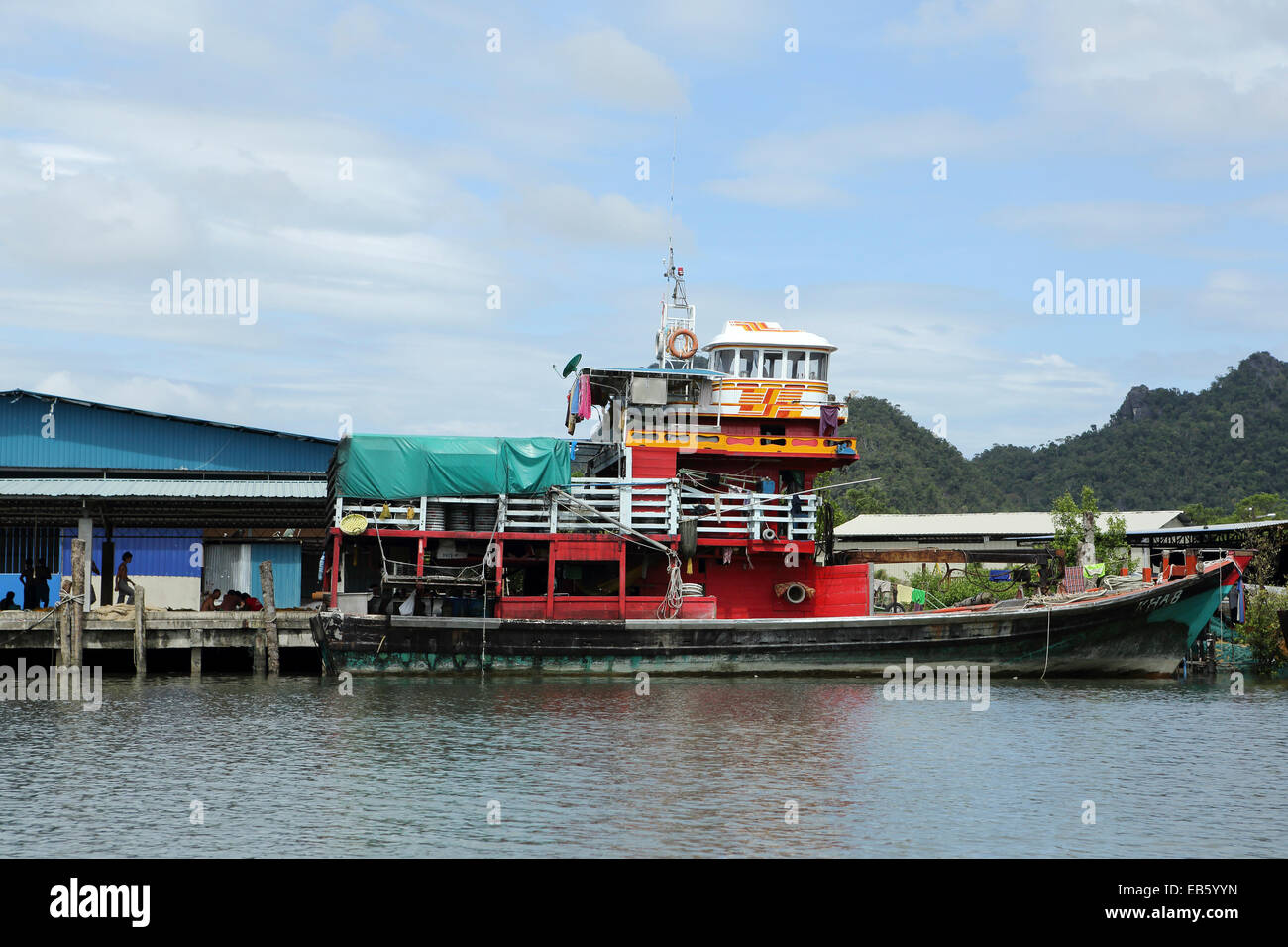An anchovy fishing boat docked within Kelim Karst Geoforest Park on Langkawi, Malaysia. Stock Photo