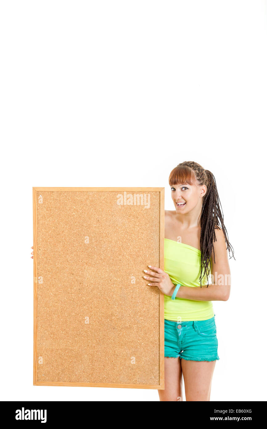 Pretty young woman holding blank cork board standing smiling , Girl holds noticeboard with advertising space for letters and tex Stock Photo