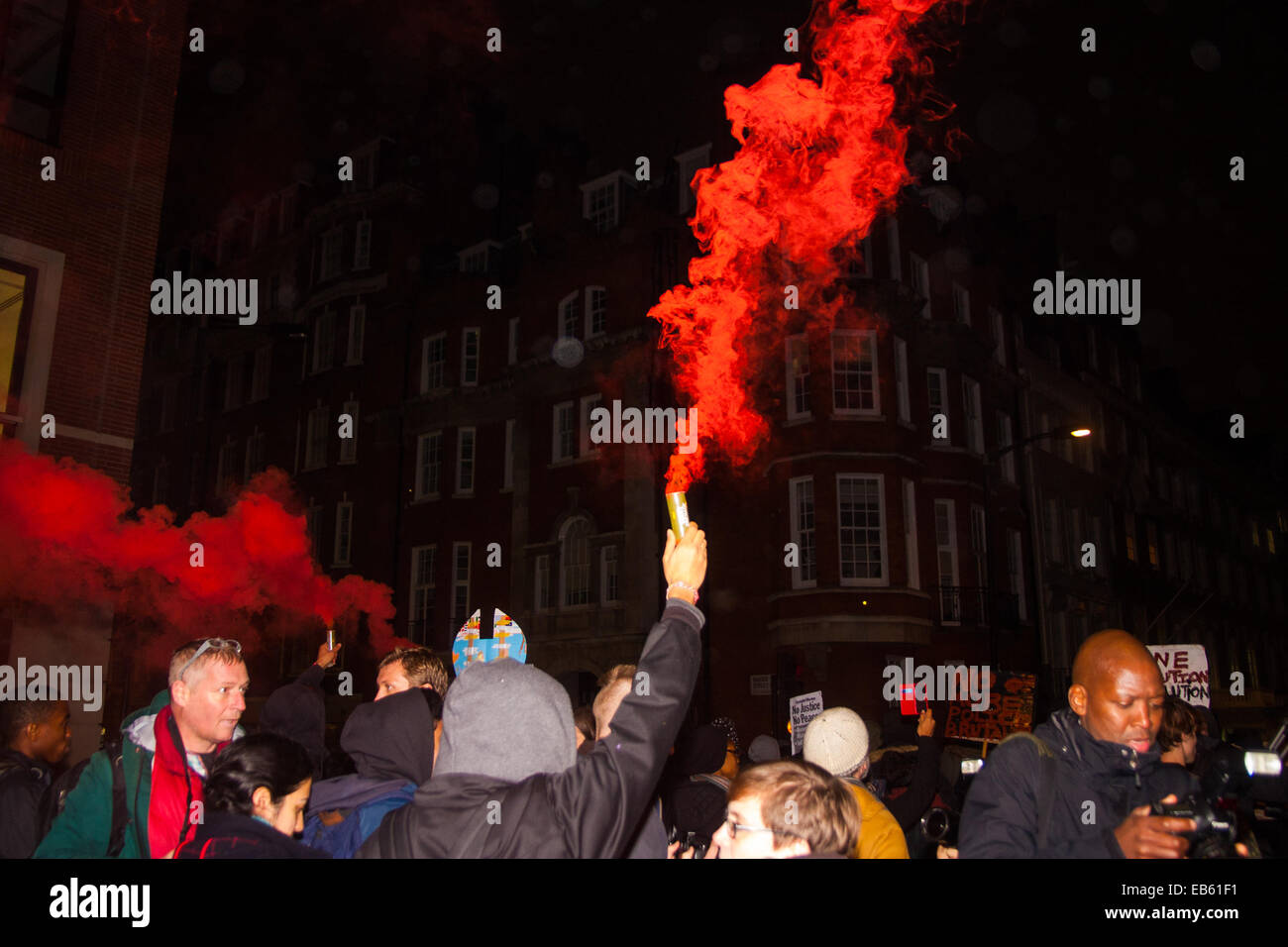 London, November 26th 2014. A vigil for teenager Mike Brown who was shot dead by a policeman in Ferguson, Missouri this year, takes place outside the US embassy in London. Anti-racism and human rights campaigners called the ‘emergency’ protest following a court verdict that clears Police Officer Darren Wilson of murder. PICTURED: Smoke flares were let off by anti-police-racism protesters as they march through London's exclusive Mayfair. Stock Photo